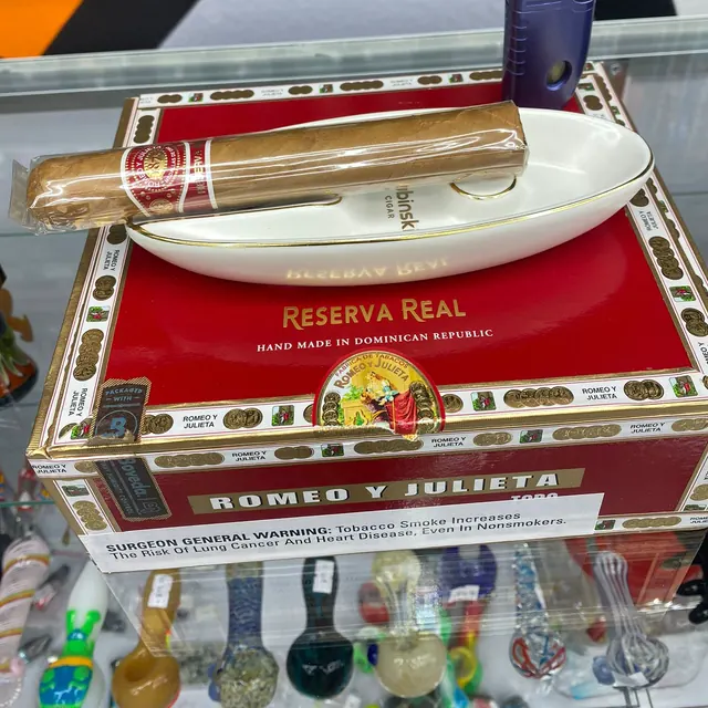 A Romeo y Julieta cigar and torch on a ceramic ashtray