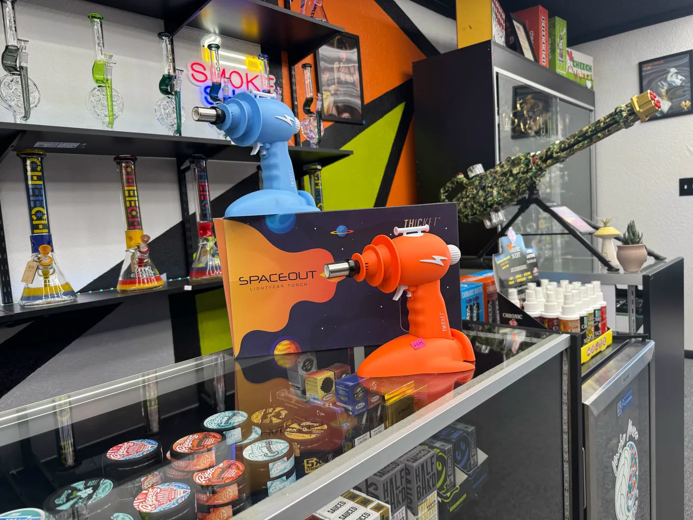 Spaceout torches on the front counter under the neon Smoke sign